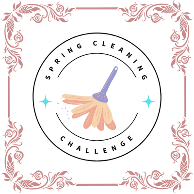 A circular badge with a feather duster in the middle. The words "Spring Cleaning" written above the feather duster with the word "Challenge" underneath. A rose gold rococo themed frame surrounds the badge.